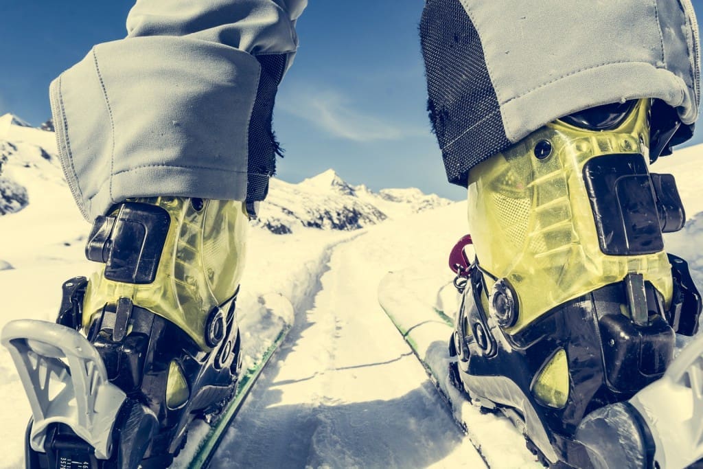 Close Up Of Skier's Boots And Skis From Ground Level.