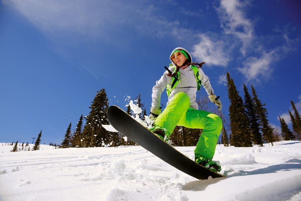 Snowboarder jumping through air with deep blue sky in background