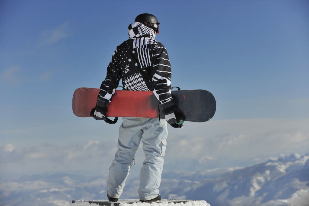 snowboarder relaxing and posing at sunny day on winter season wi