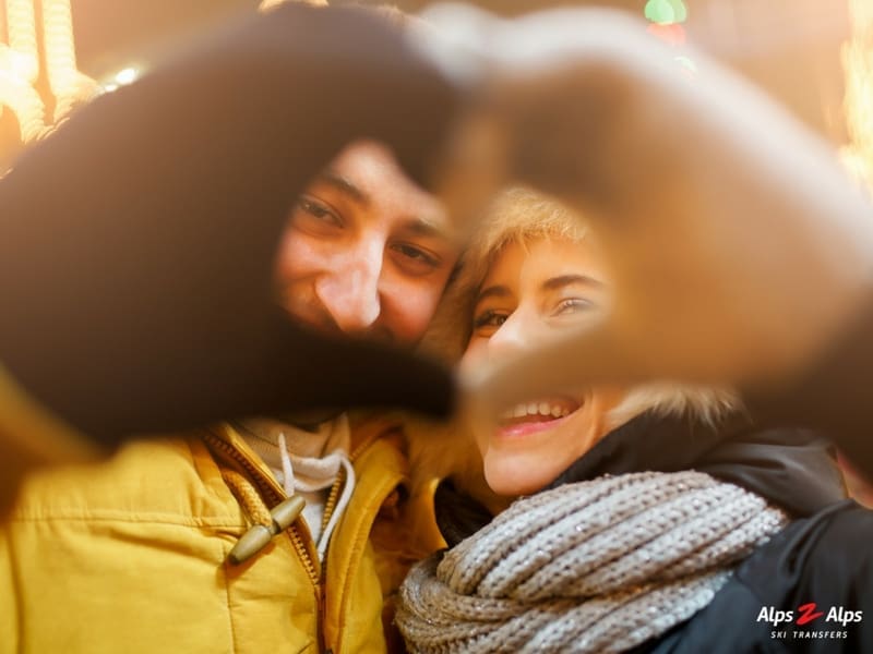 Couple making a heart sign with their hands for Valentine's Day on the slopes