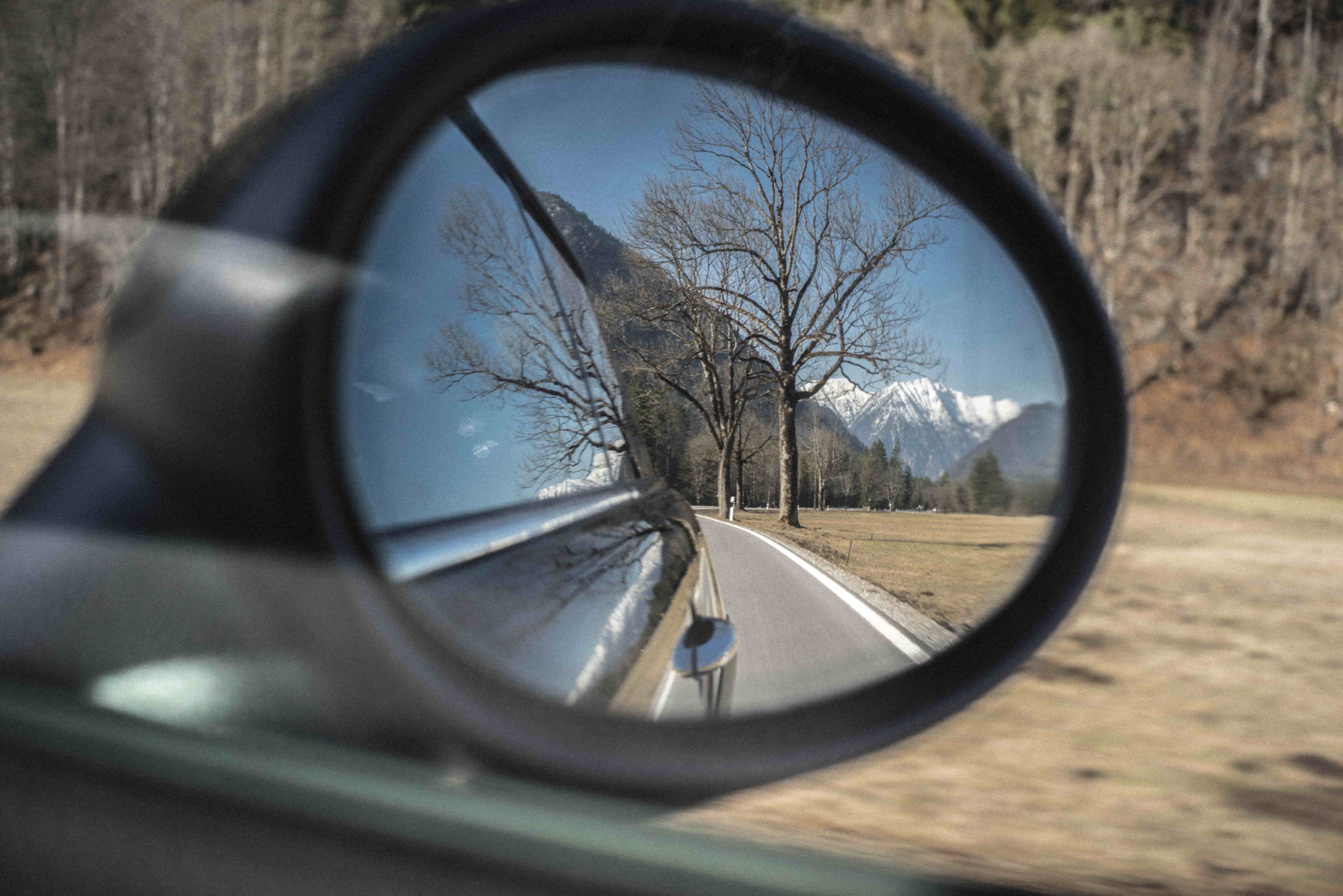 View of the Alps from car wing mirror