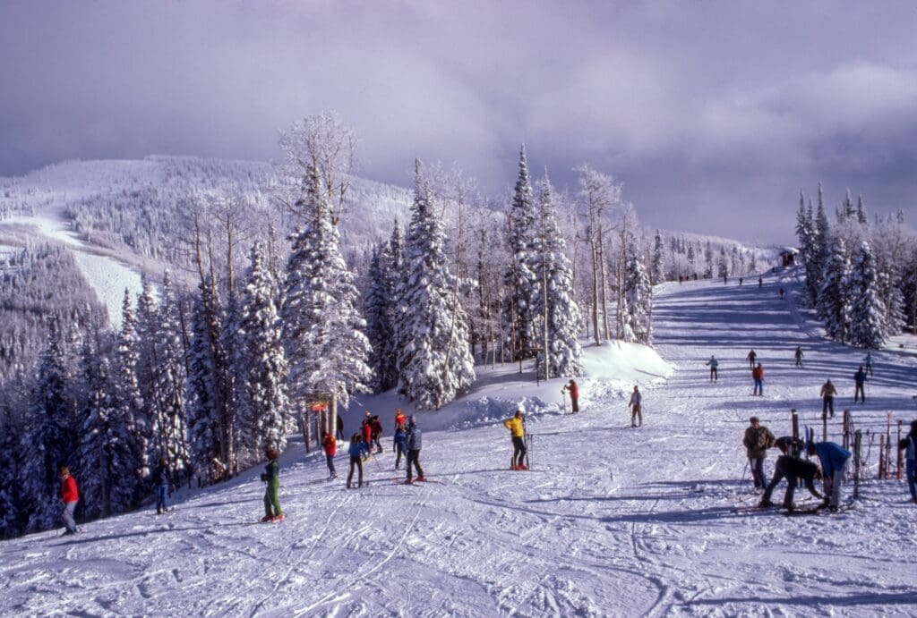 Far away shot of lots of people skiing on a slope