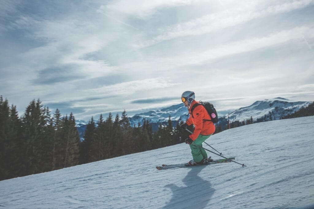 Side shot of man skiing down a snowy mountain