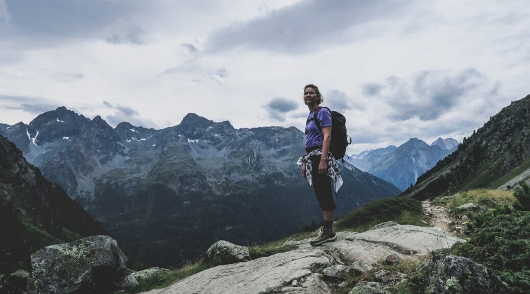 Lady in hiking gear walking up an Alps mountain