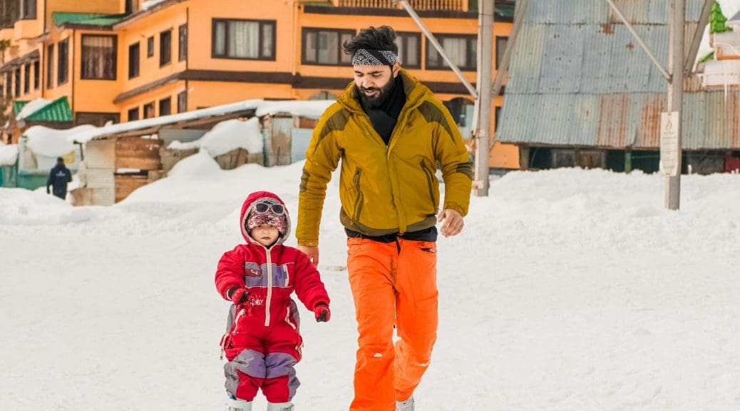 Father helping child to ski