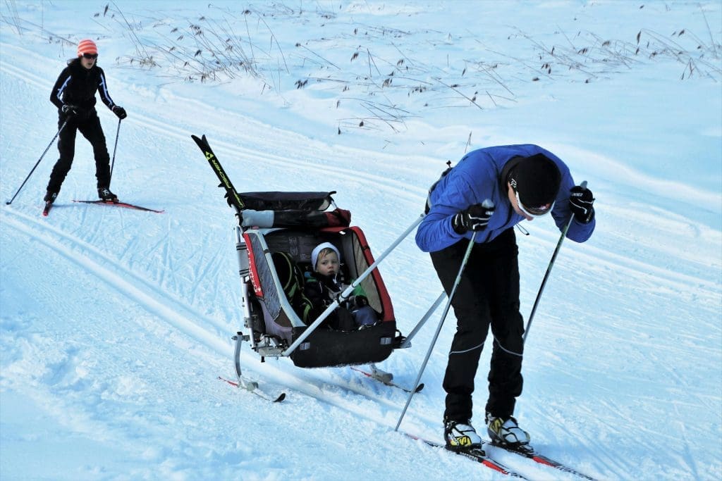 Father pulling child along on skis