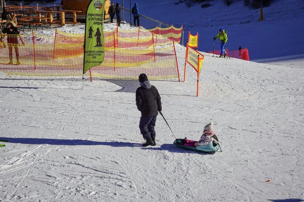 Pulling a child along on a sled on the Alpine slopes